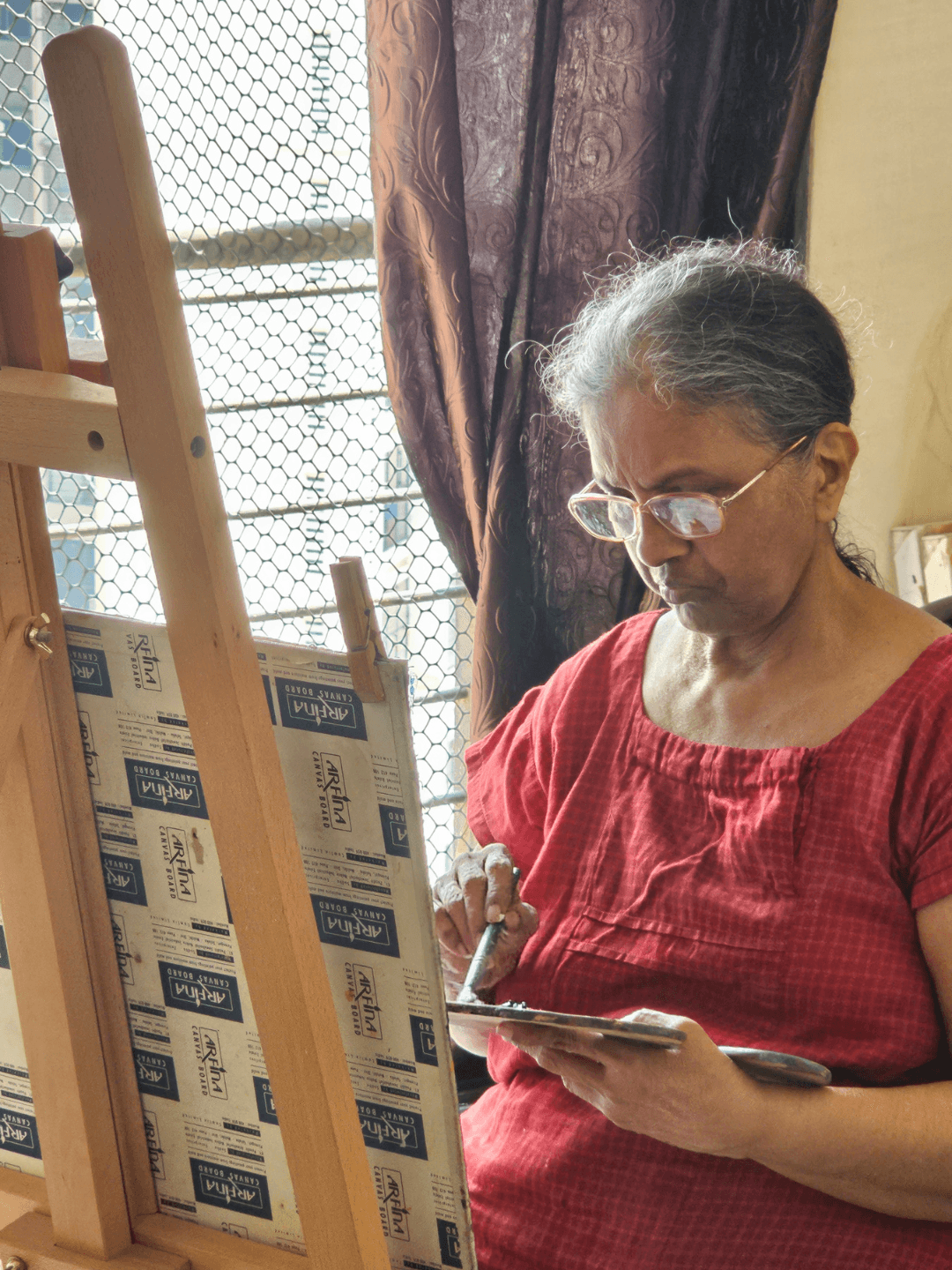 Renatha Fernandes painting at her easel